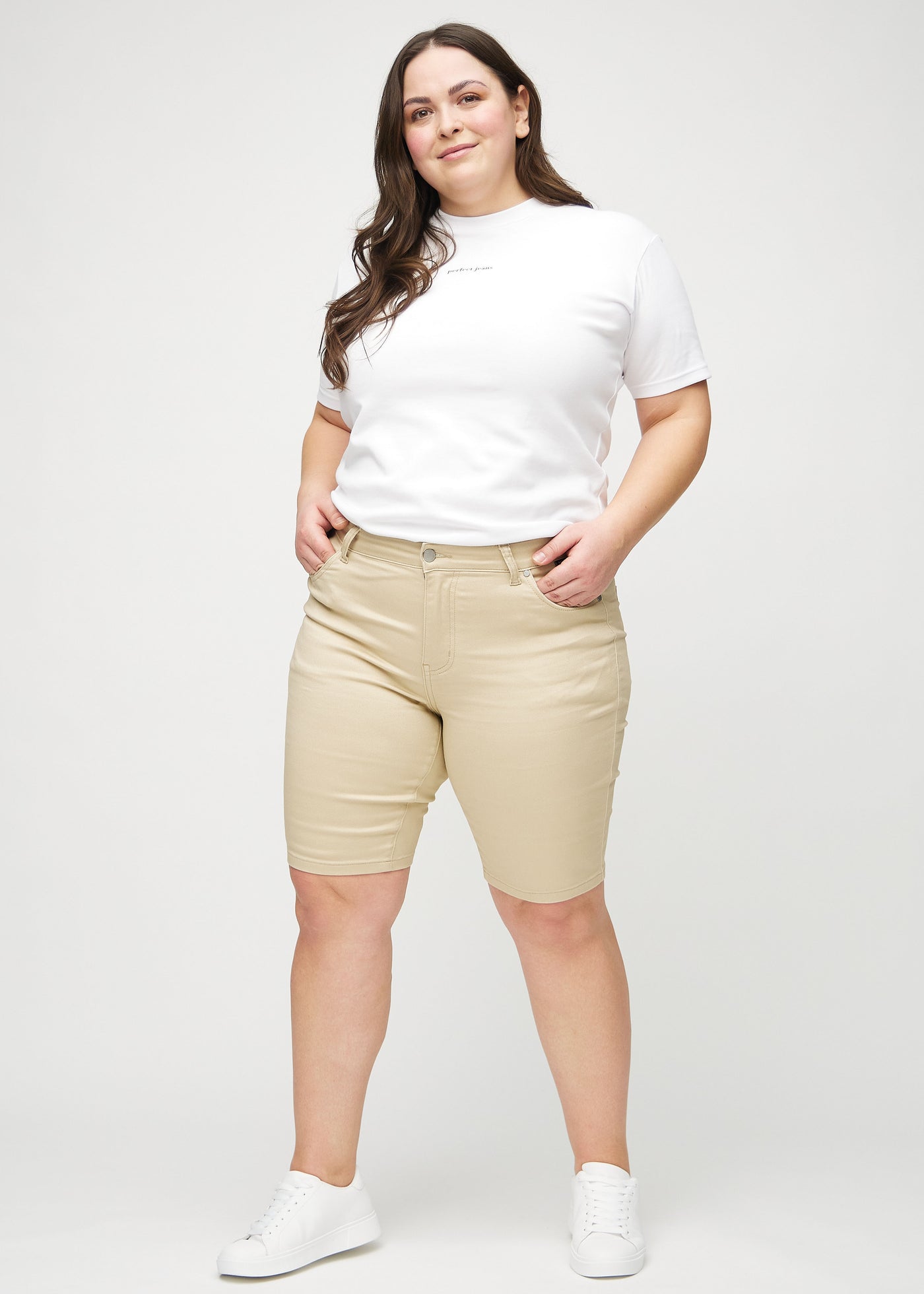 Fuldt billede af en plus-size model i beige skinny middle shorts.