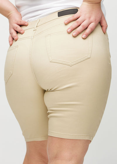 Beige skinny middle shorts set bagfra tæt på en plus-size model for at vise detaljer.