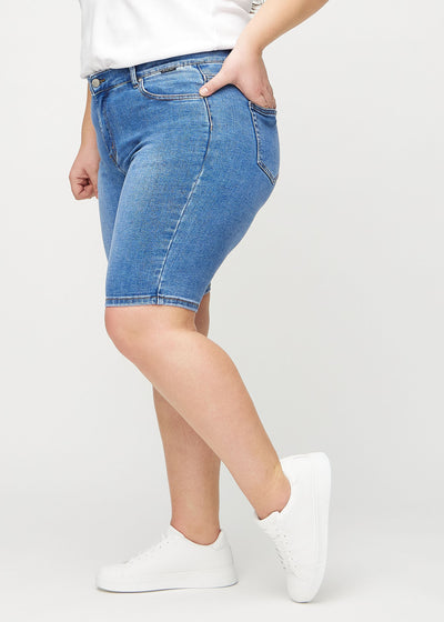 Denim skinny middle shorts set fra siden på en plus-size model.