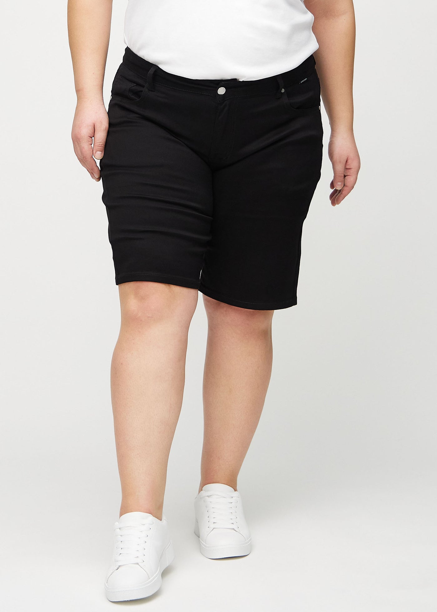 Sorte regular middle shorts, modelnavn Ravens, som går lige ned langs benet og slutter lige over knæet på en plus-size model, set forfra.