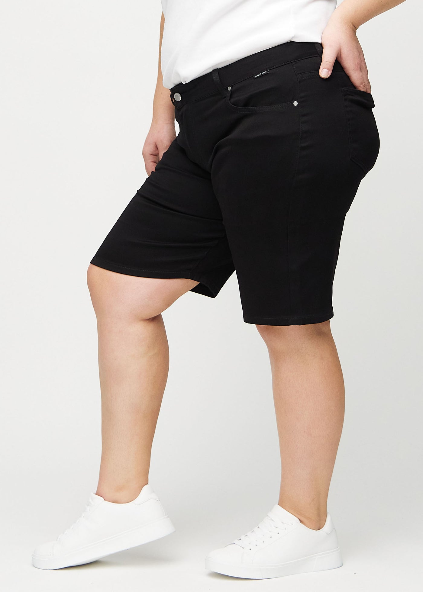 Sorte regular middle shorts set fra siden på en plus-size model.