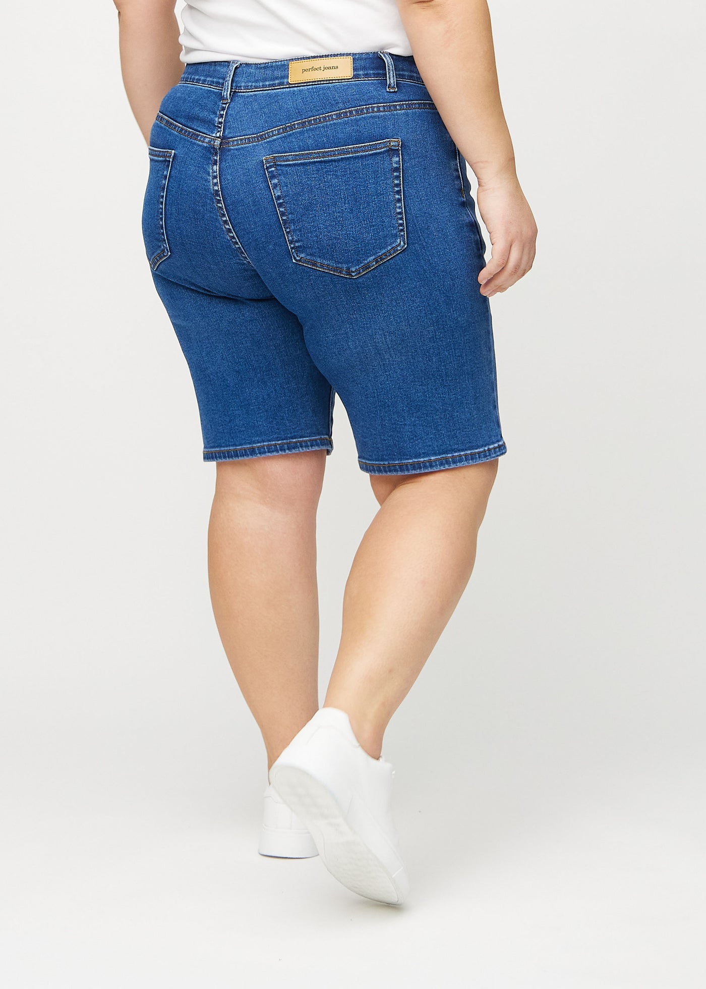 Mørk denim regular middle shorts set bagfra på en plus-size model, så man kan se hele produktet.