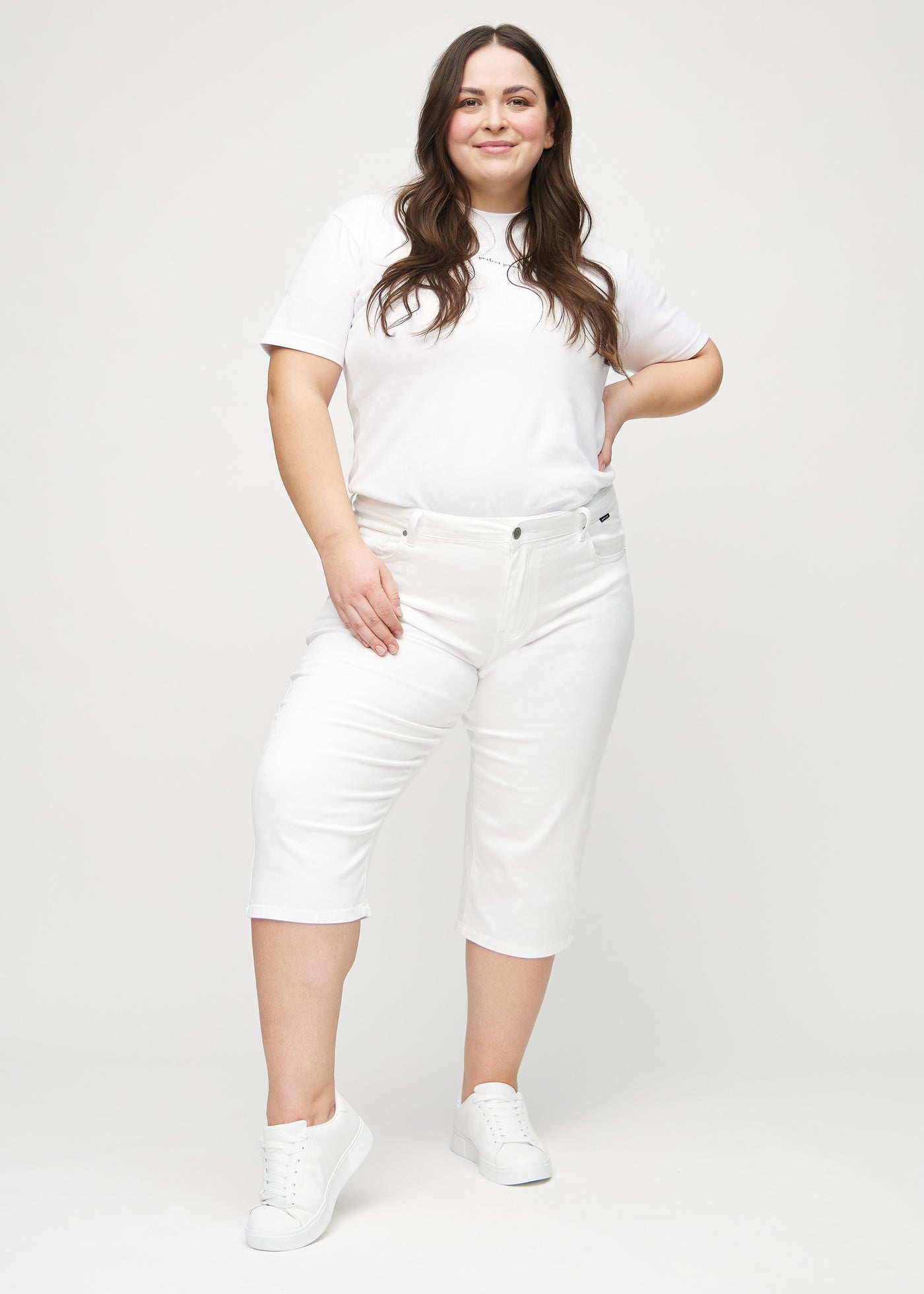 Fuldt billede af en plus-size model i hvide regular capris.