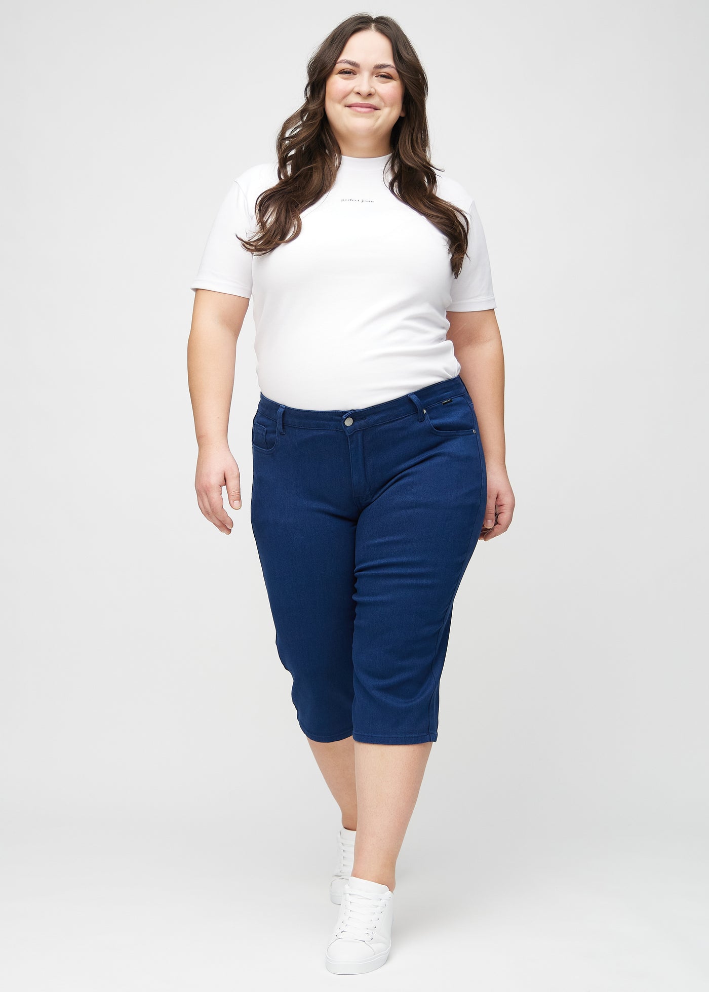 Fuldt billede af en plus-size model i mørkeblå regular capris.