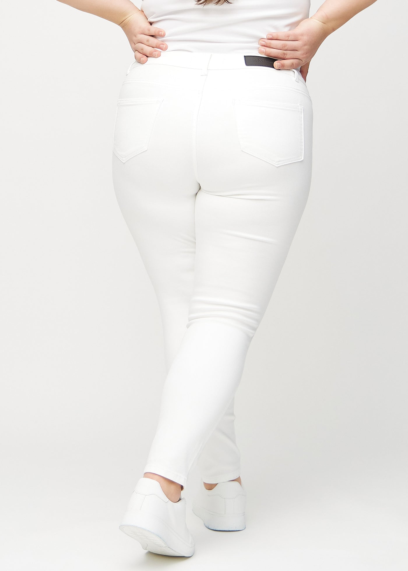 Hvide skinny jeans set bagfra på en plus-size model, så man kan se hele produktet.