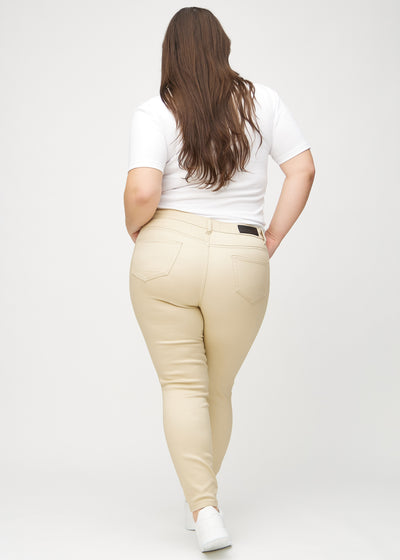 Beige skinny jeans set bagfra på en plus-size model, så man kan se hele produktet.