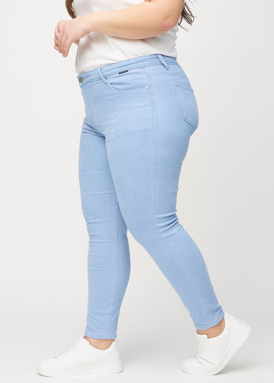 Lyseblå skinny jeans set fra siden på en plus-size model.