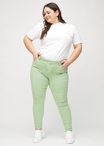 Fuldt billede af en plus-size model i lysegrønne skinny jeans.