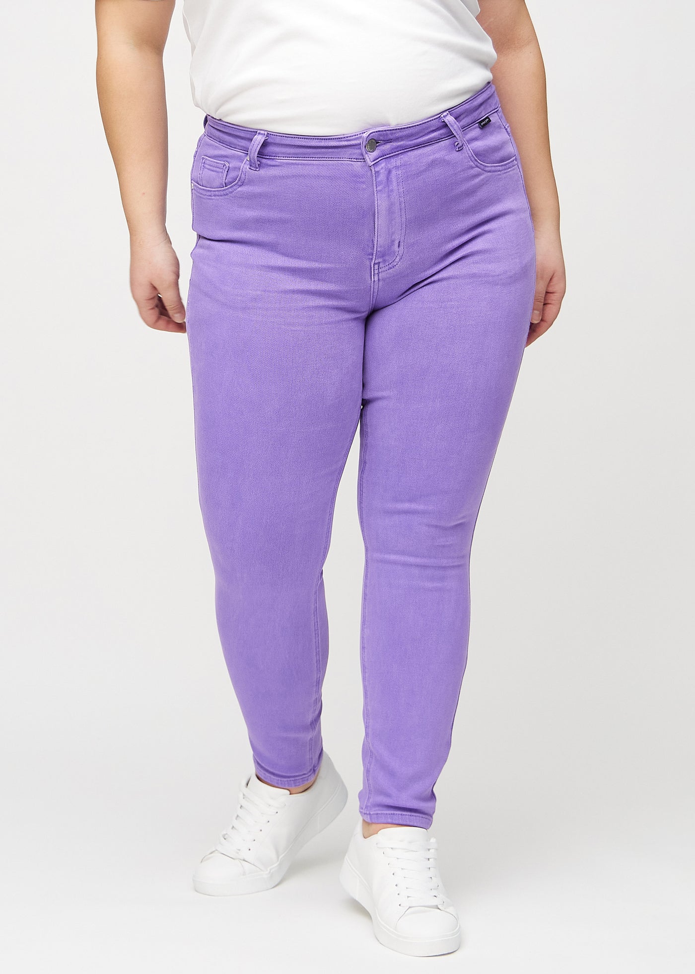 Lilla skinny jeans, modelnavn Lavenders, som sidder tæt til benet på en plus-size model, set forfra.