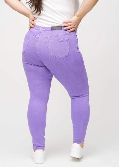 Lilla skinny jeans set bagfra på en plus-size model, så man kan se hele produktet.