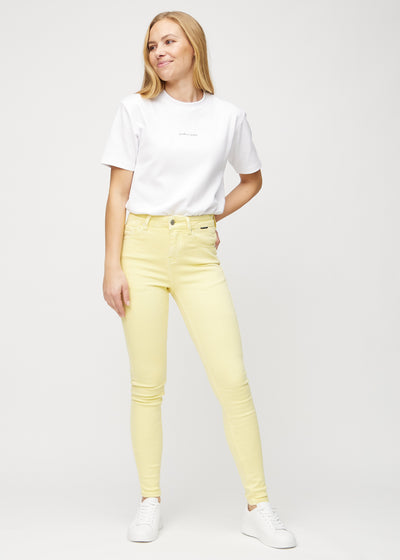 Fuldt billede af model i lysegule skinny jeans.