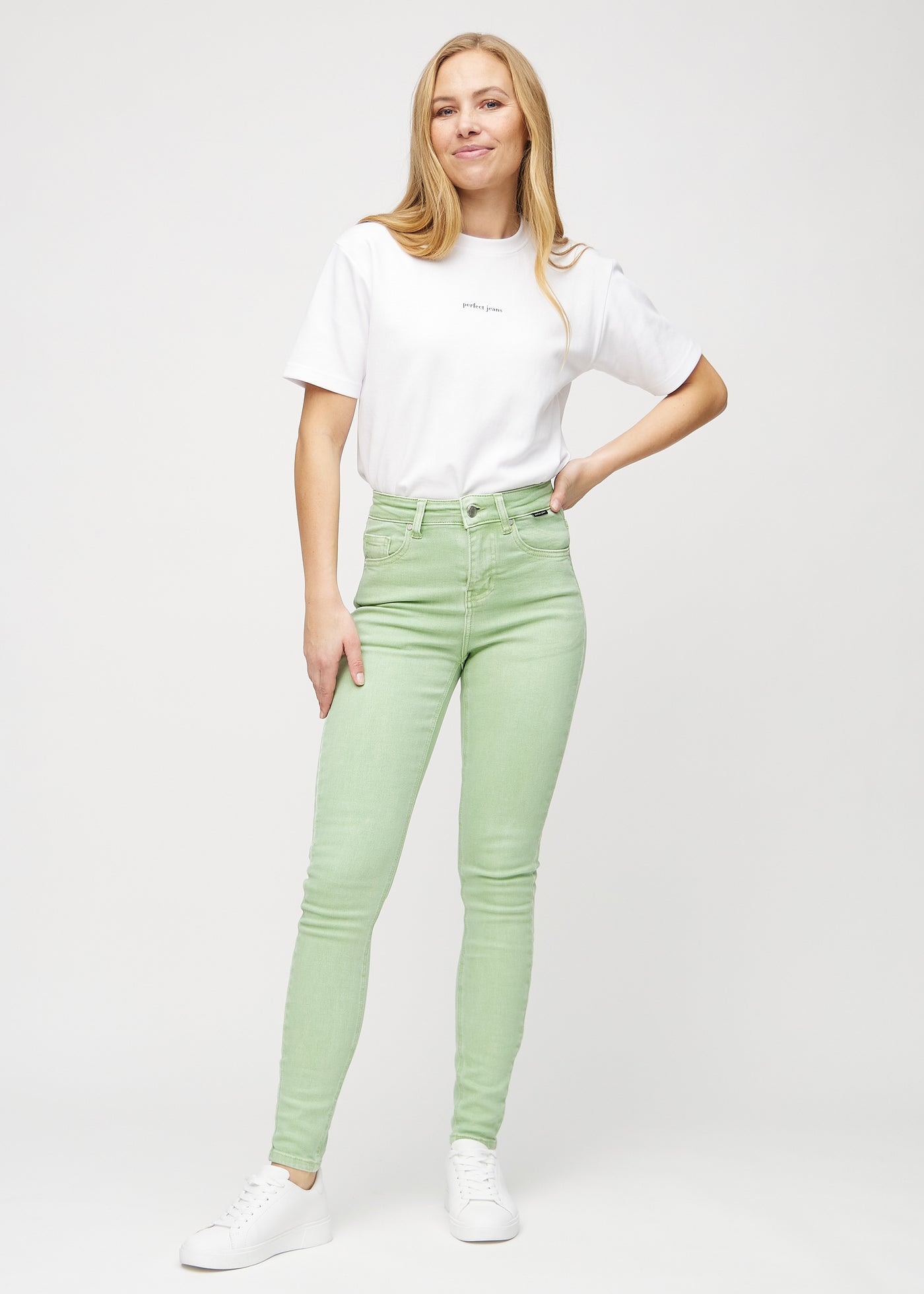 Fuldt billede af model i lysegrønne skinny jeans.