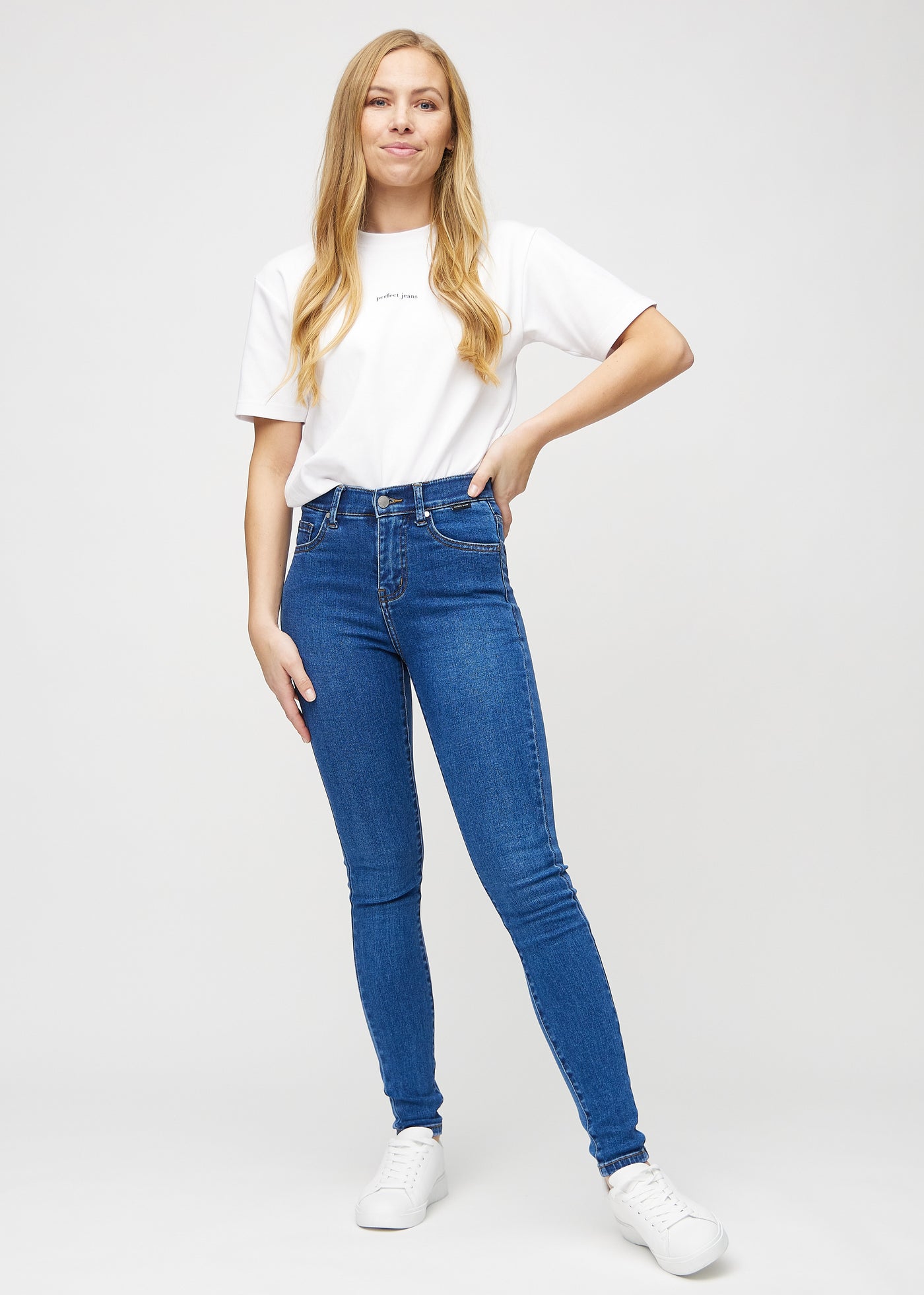 Fuldt billede af model i mørk denim skinny jeans.