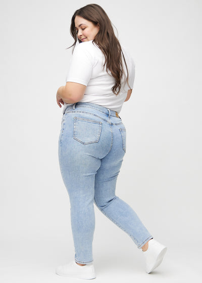 Lys denim slim ultra high rise jeans set fra siden på en plus-size model.