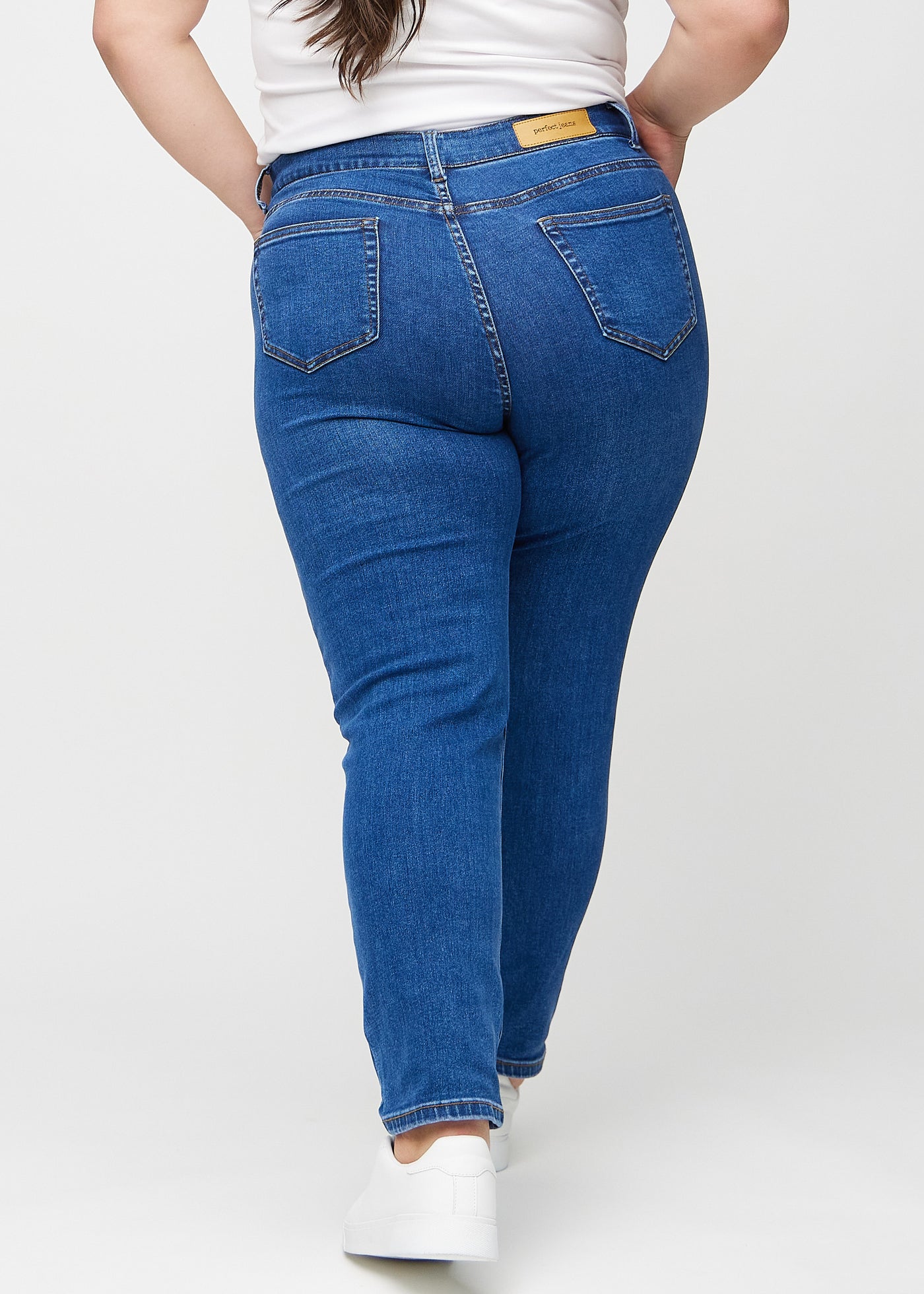 Mørk denim slim jeans set bagfra på en plus-size model, så man kan se hele produktet.