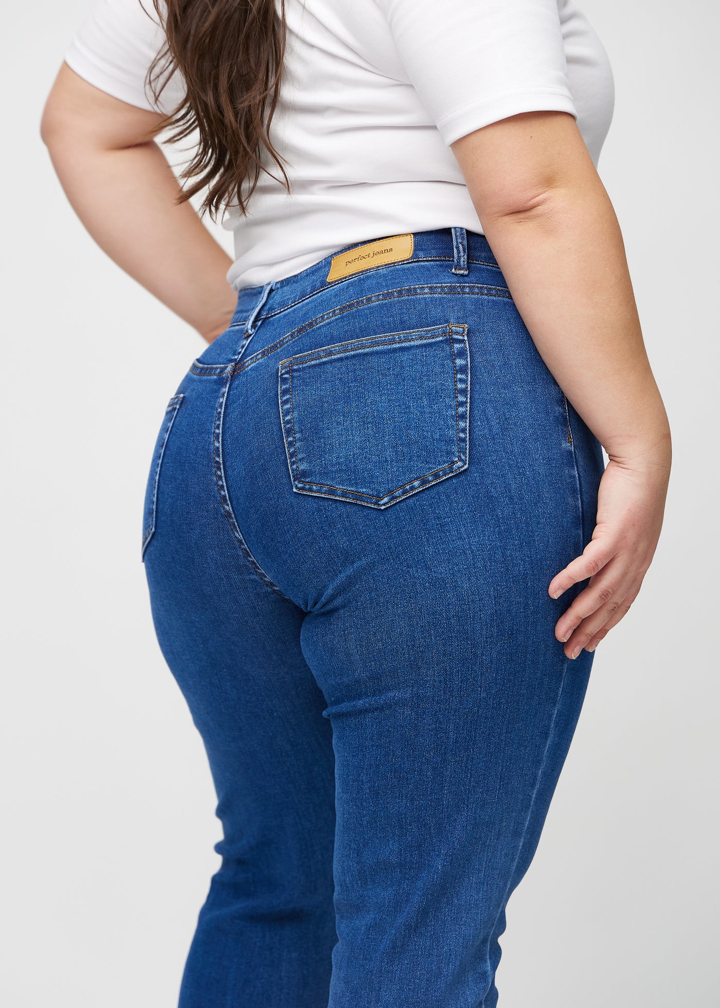 Mørk denim slim ultra high rise jeans set bagfra tæt på en plus-size model for at vise detaljer.