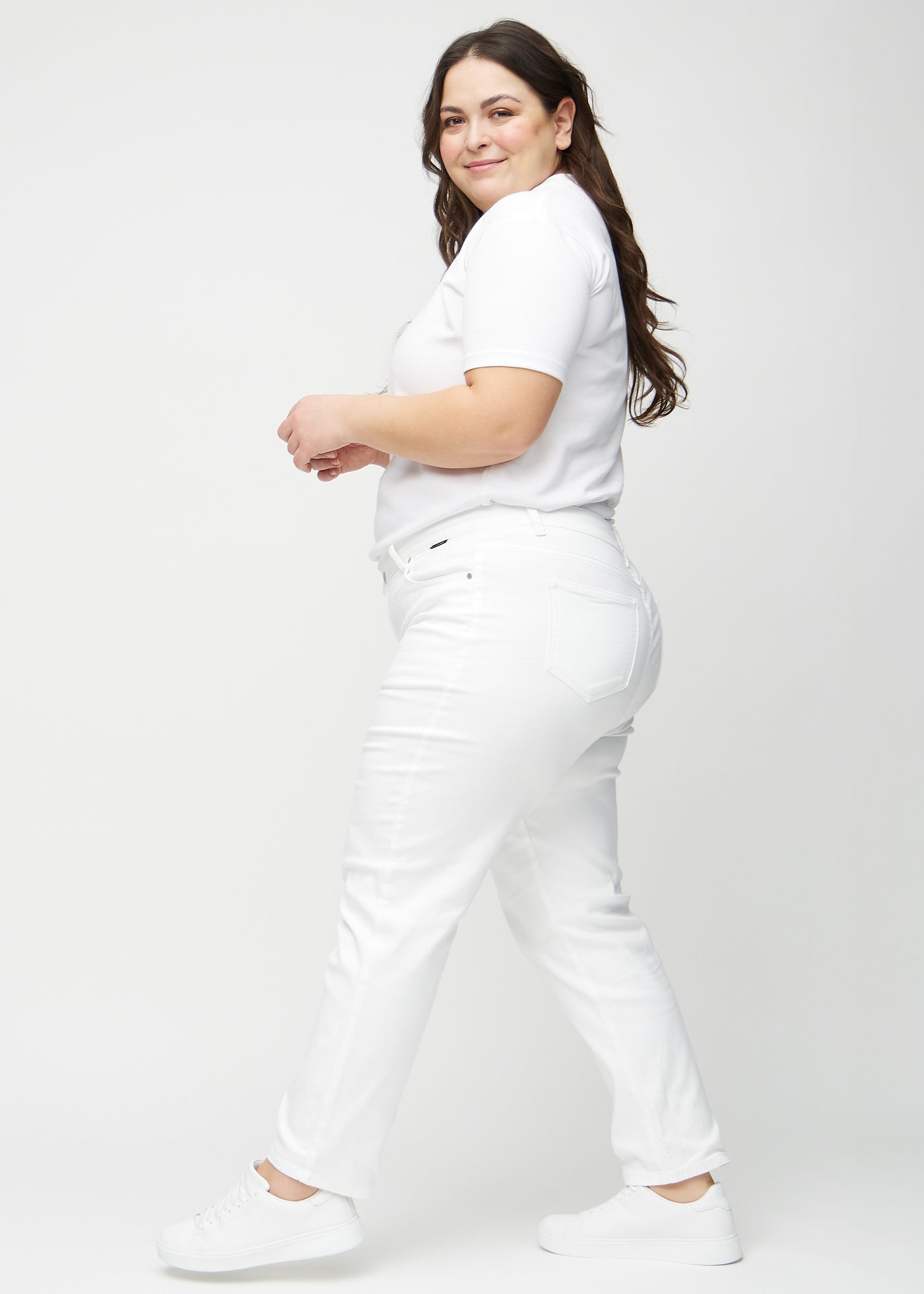 Hvide regular jeans set fra siden på en plus-size model.