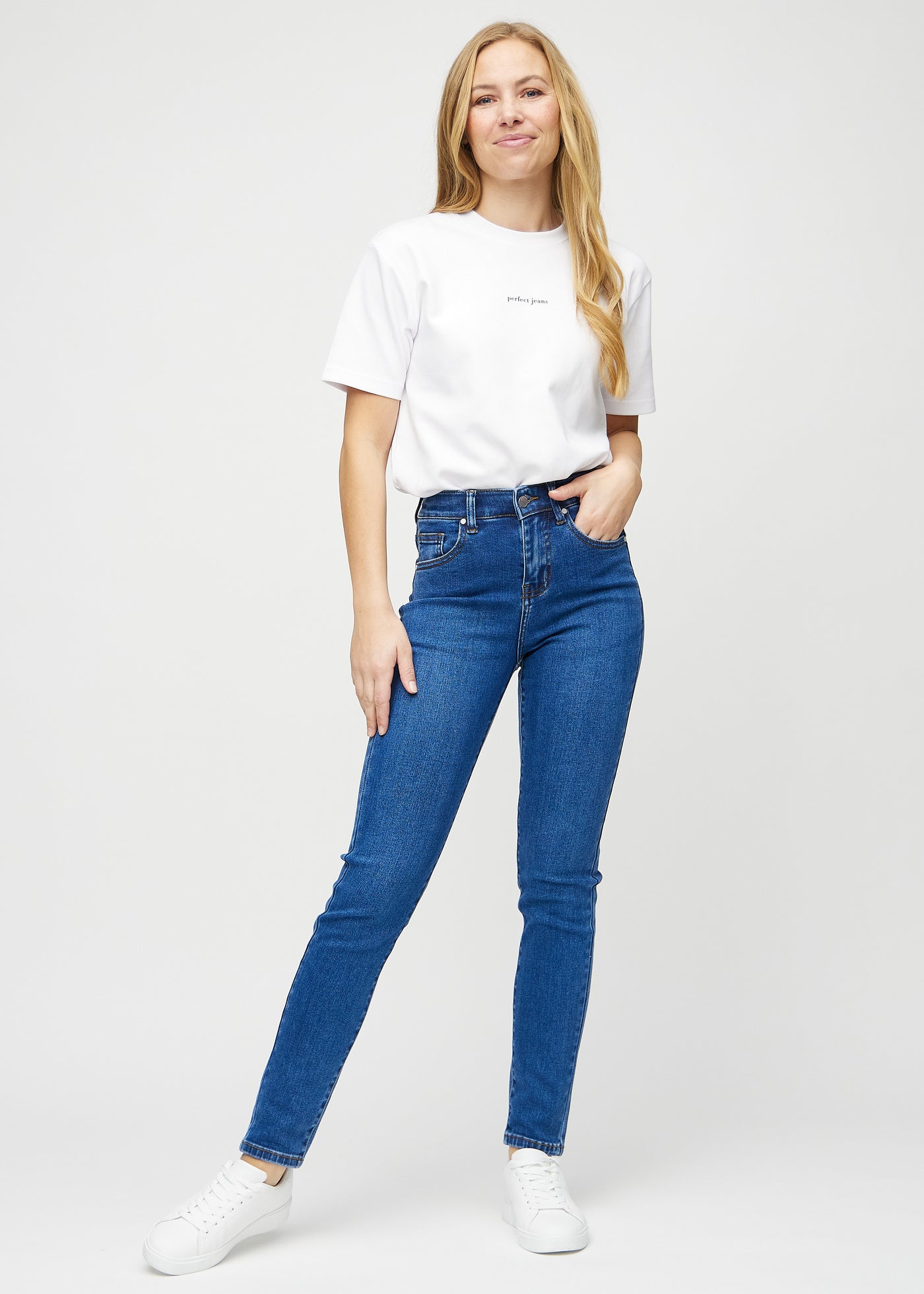 Fuldt billede af model i mørk denim slim jeans.