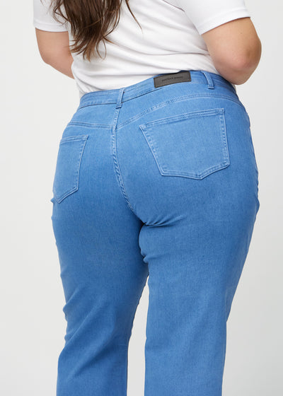 Blå loose jeans set bagfra tæt på en plus-size model for at vise detaljer.