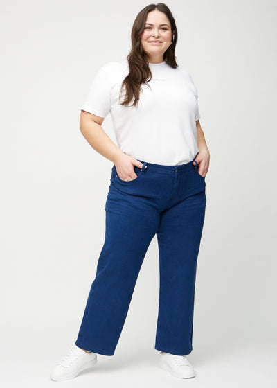 Fuldt billede af en plus-size model i mørkeblå loose jeans.