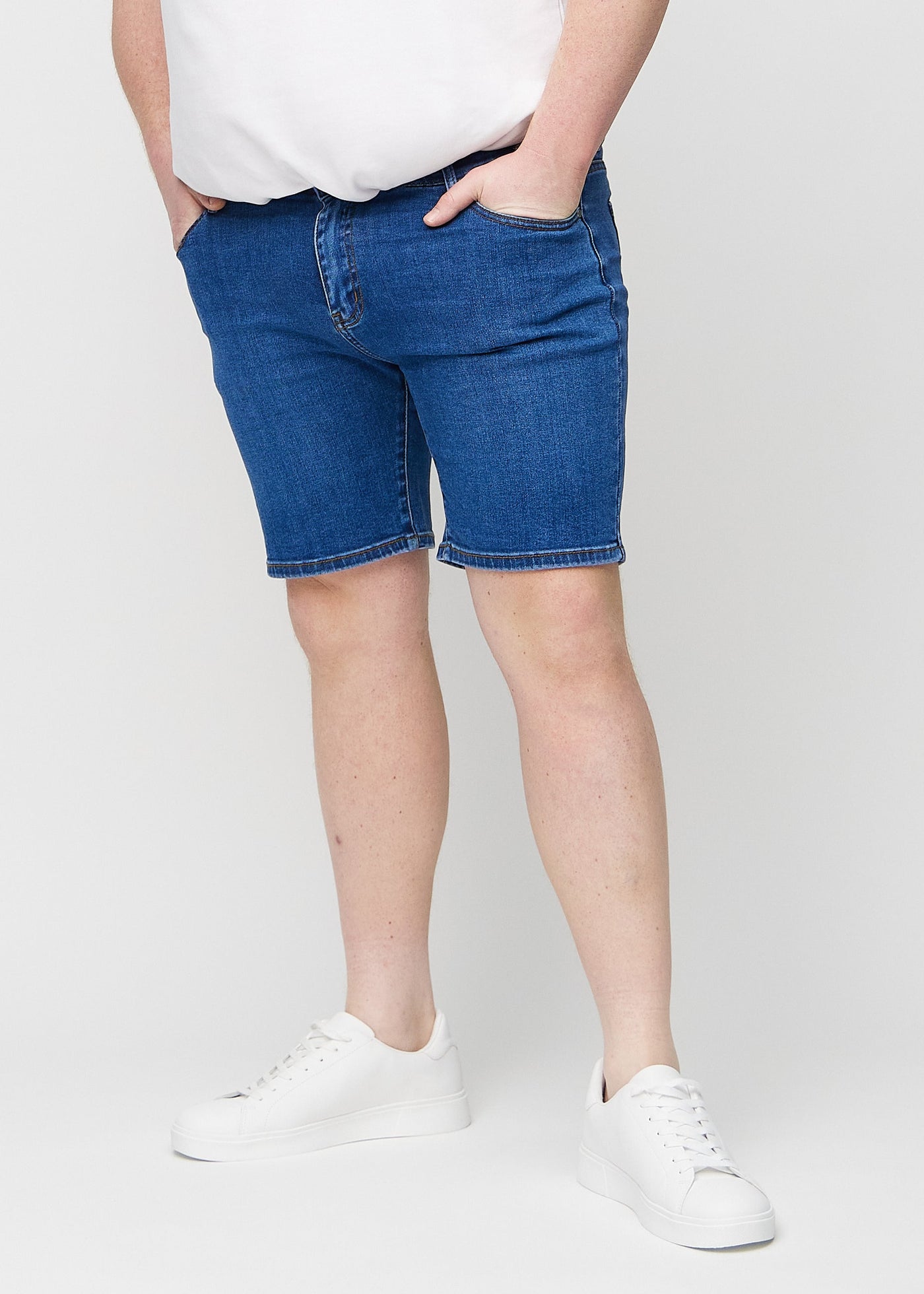 Mørk denim regular middle shorts, som sidder lige langs låret og slutter lige over knæet på en plus-size model, set forfra.