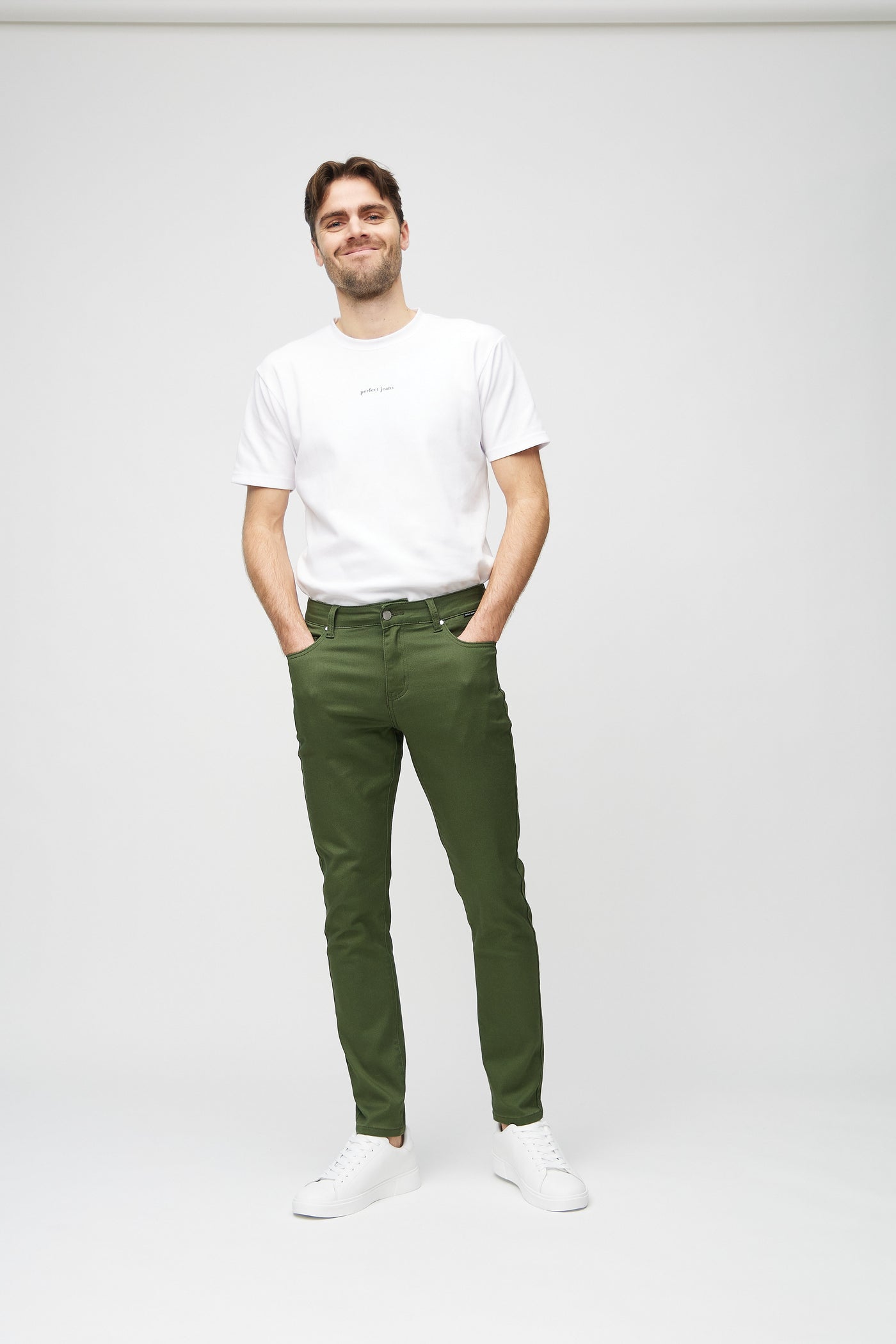 Fuldt billede af model i mørkegrønne slim jeans.