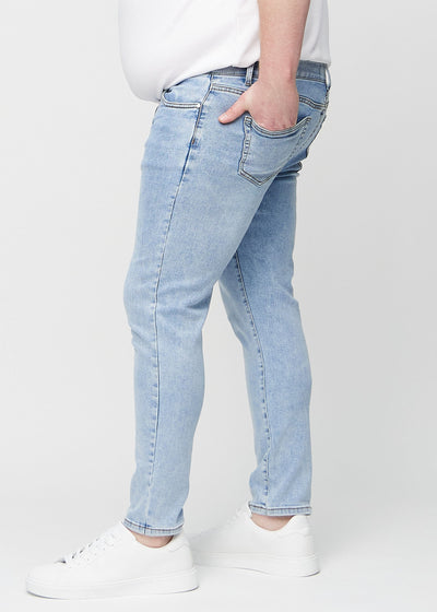 Lys denim slim jeans set fra siden på en plus-size model.