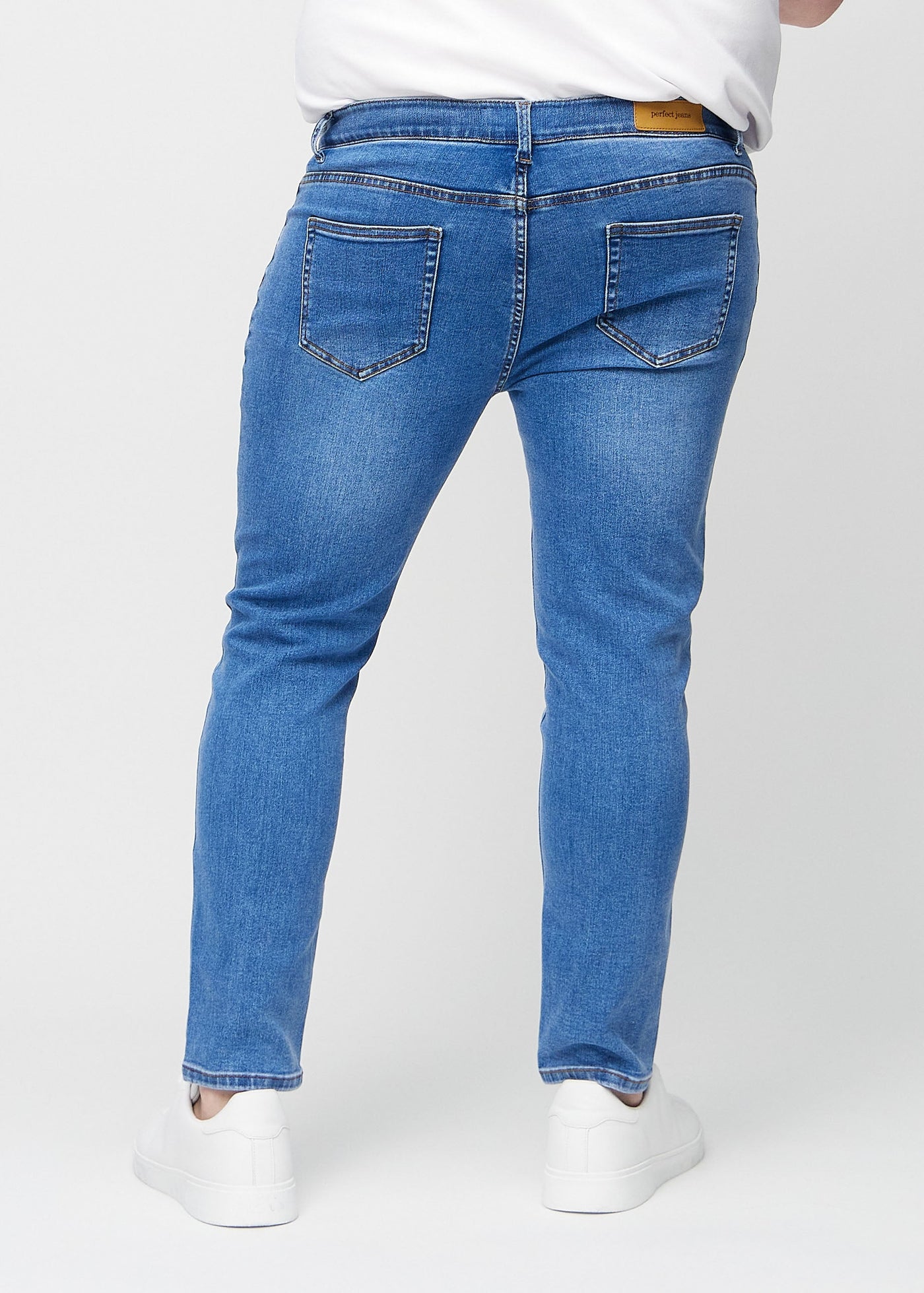 Denim slim jeans set bagfra på en plus-size model, så man kan se hele produktet.