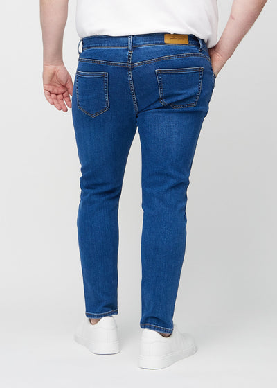 Mørk denim slim jeans set bagfra på en plus-size model, så man kan se hele produktet.