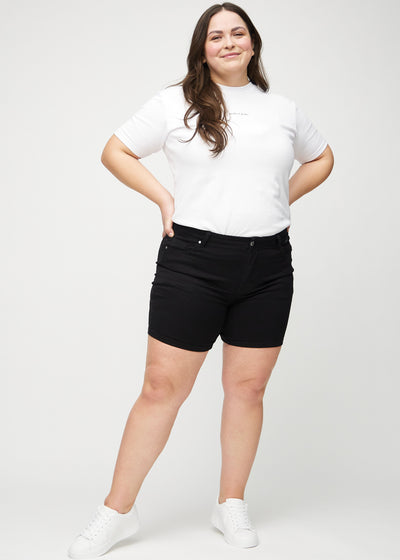 Plus-size model går ind i billedet, strækker i sine shorts, viser dem frem ved at dreje rundt, og forlader derefter billedet.